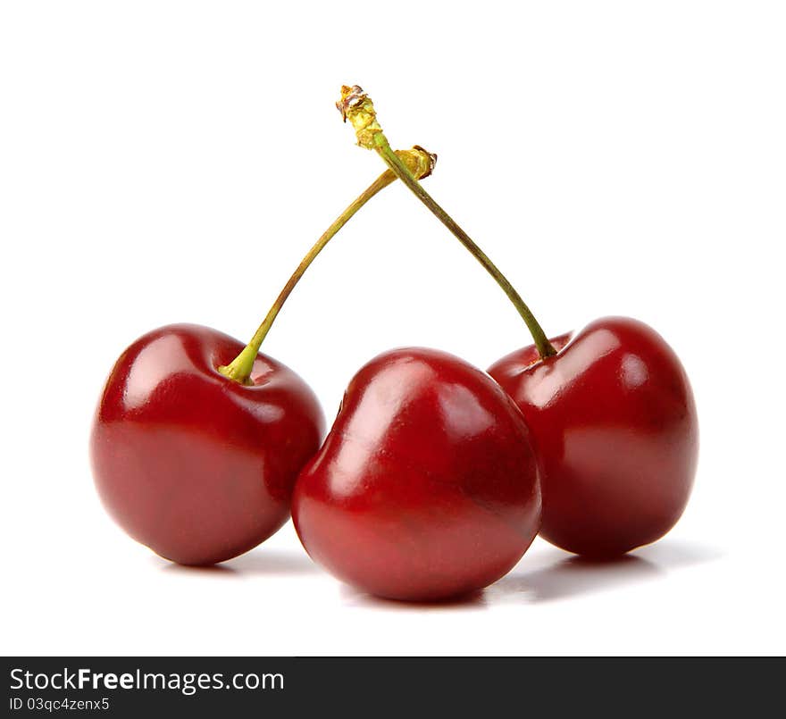 Three red ripe cherries lie on a white background. Three red ripe cherries lie on a white background