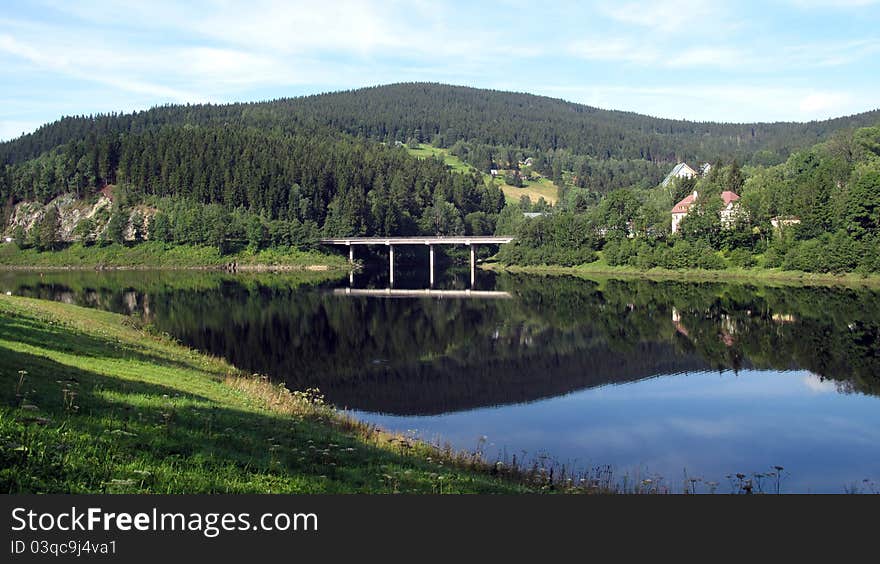 Bridge across the crystal-clear river. Bridge across the crystal-clear river