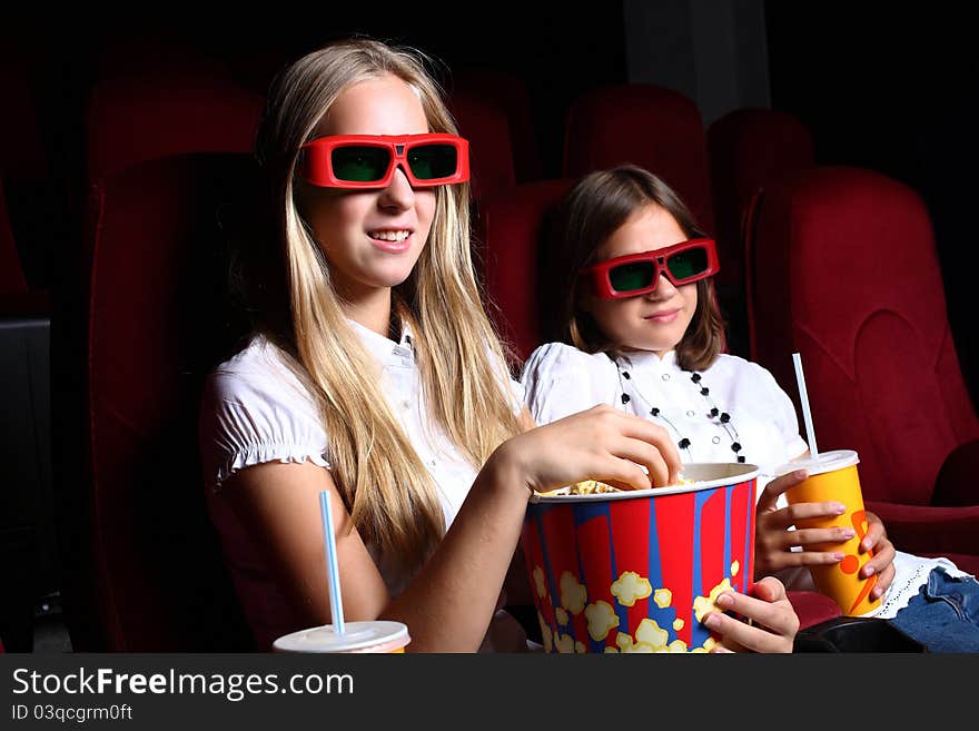Two young girls watching movie in cinema. Two young girls watching movie in cinema