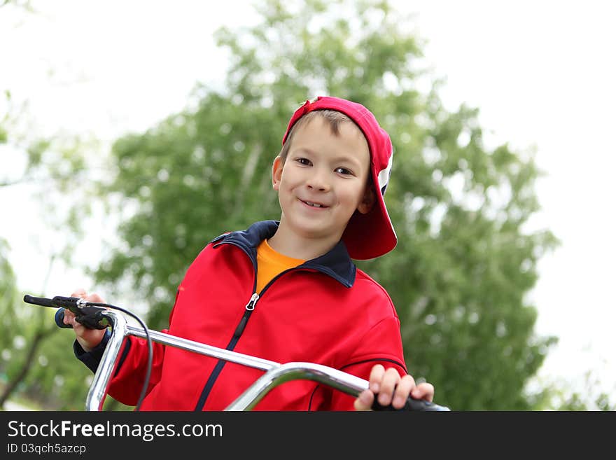 Happy smiling boy on a bicycle in the green park