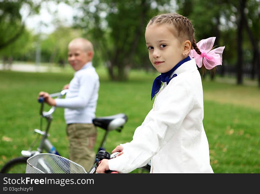 Happy smiling girl on a bicycle in the green park