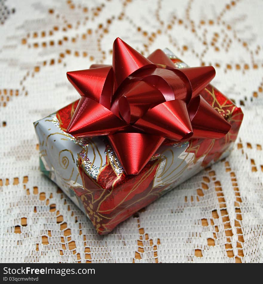 Single boxed Christmas gift with red bow