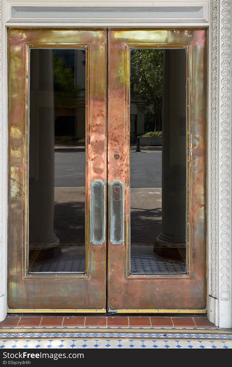 Crafty brass door with windows with street reflection