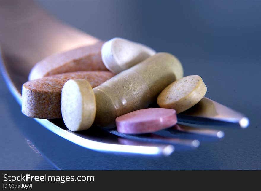 Close up of various pills on fork