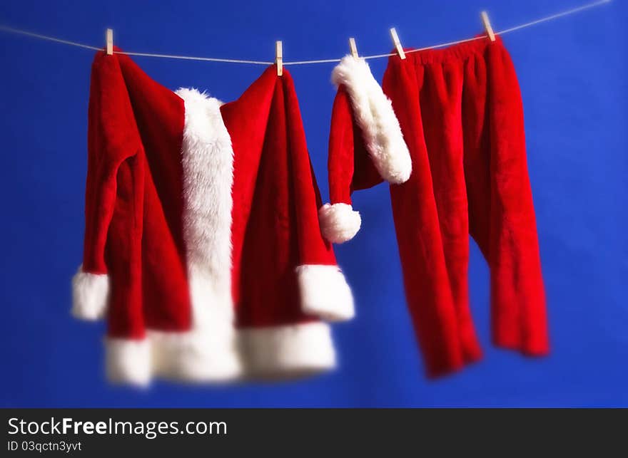 Santa's outfit hanging on line with blue background. Santa's outfit hanging on line with blue background