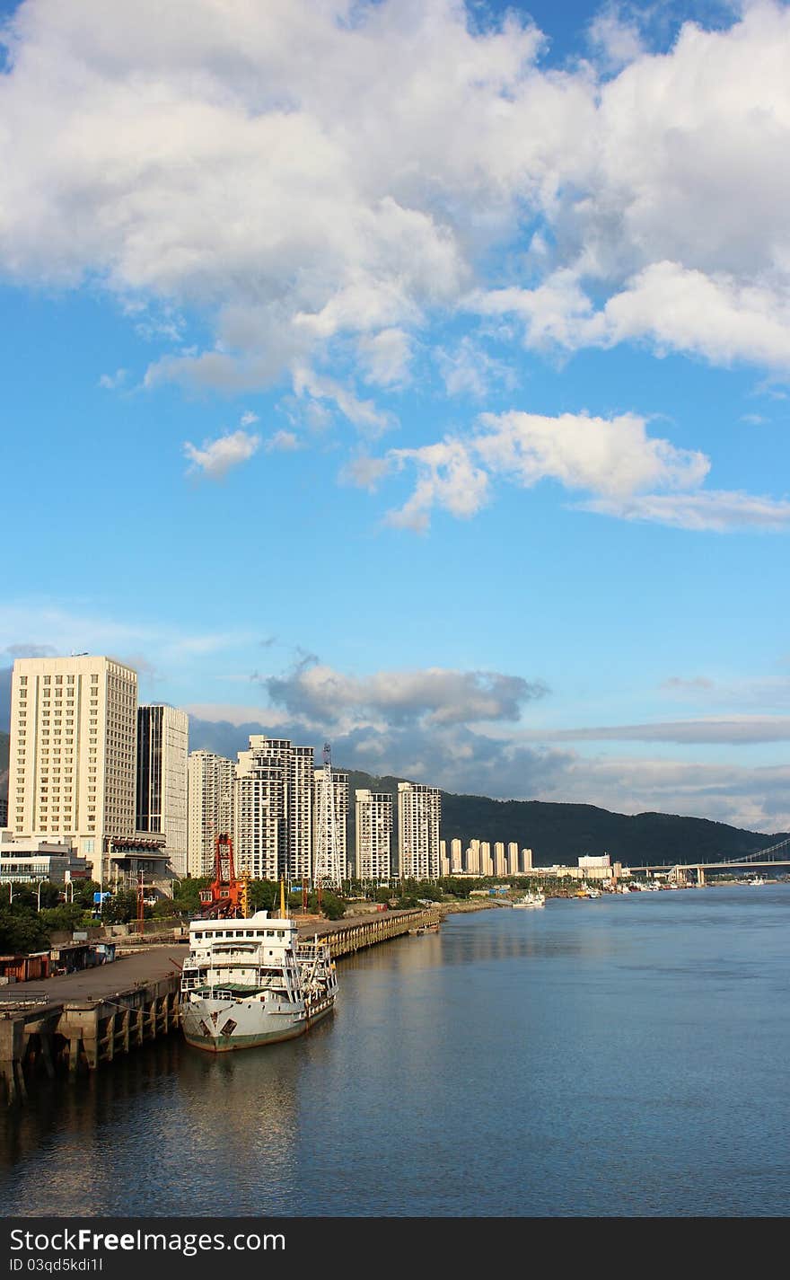 The cbd is located by the riverside,yacht,blue water and sky look beautiful. The cbd is located by the riverside,yacht,blue water and sky look beautiful