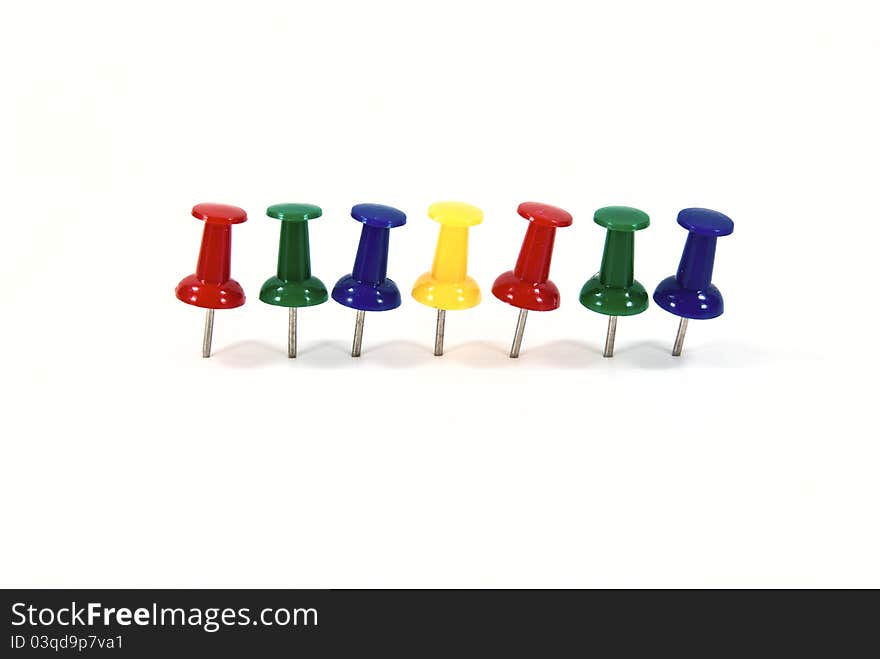 Multi color push pin shot on white background.