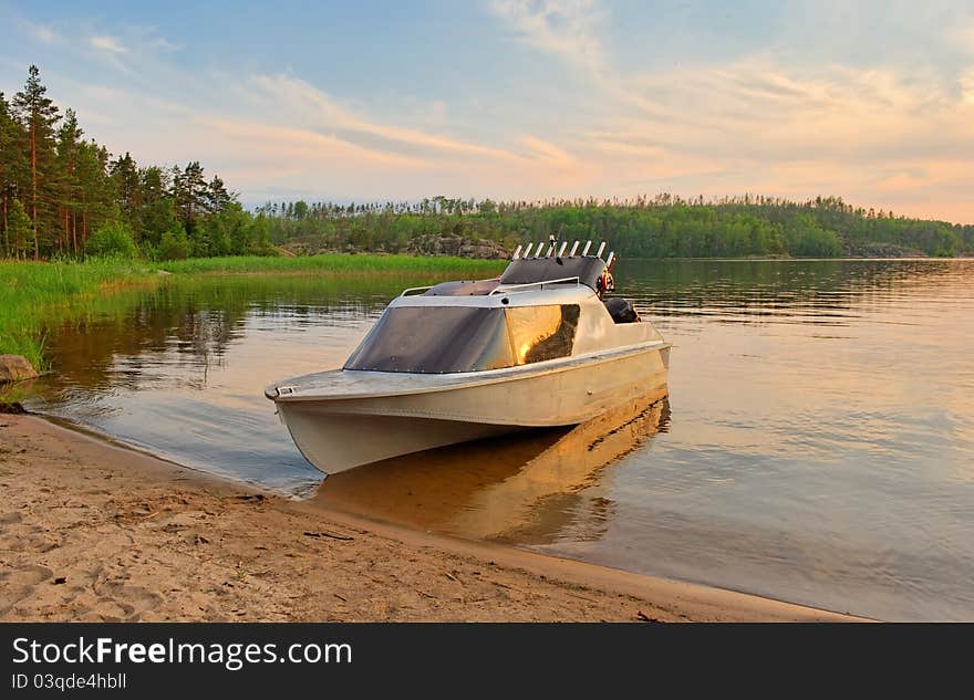 Powerboat on lakeshore in early evening