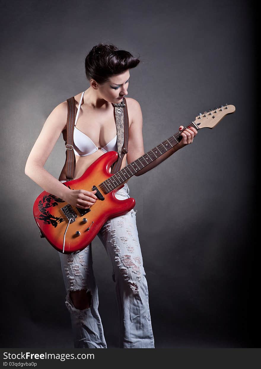 Sexy girl with a guitar playing rock