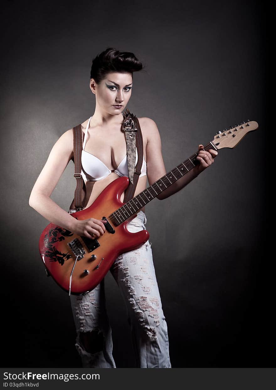 Sexy girl with a guitar playing rock