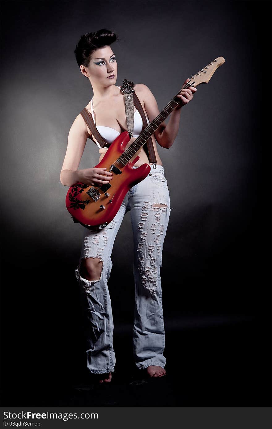 Sexy girl with a guitar playing rock