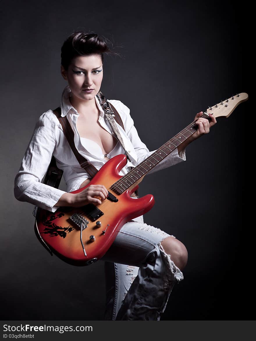 Sexy girl with a guitar playing rock