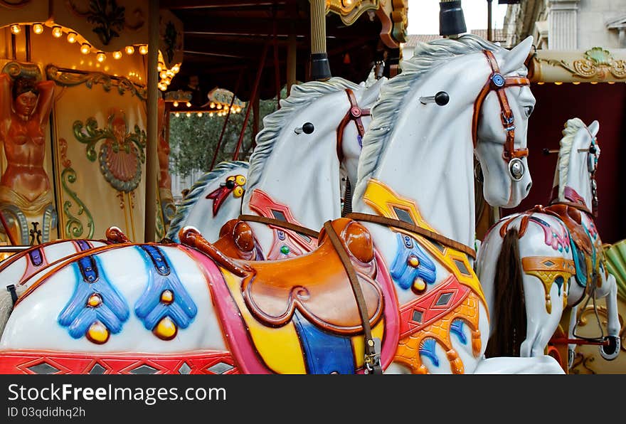 Colorful horses as part of a vintage merry-go-round for children on a playground at an entertainment area