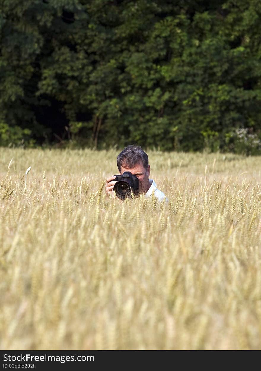 Fotographer in corn field with camera