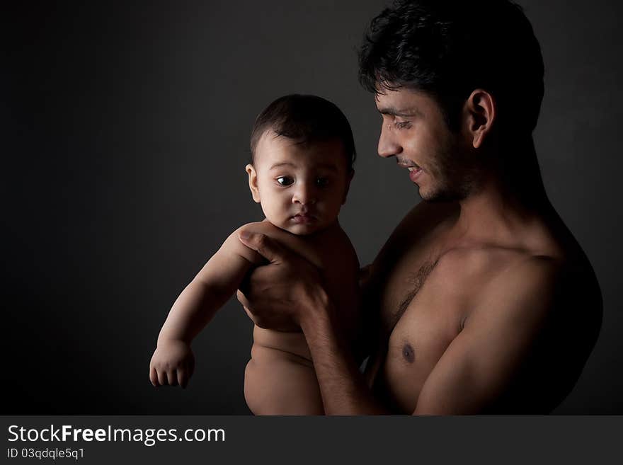 Indian father and son in happy pose over black background. Indian father and son in happy pose over black background