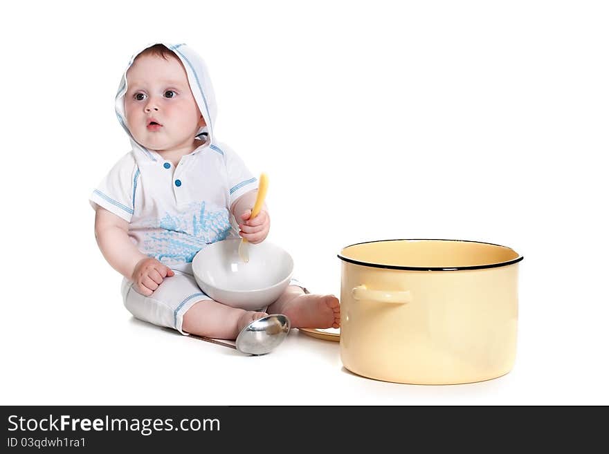 Funny little boy wearing white overalls with a hood playing with the dishes studio portrait (isolated on white background). Funny little boy wearing white overalls with a hood playing with the dishes studio portrait (isolated on white background)