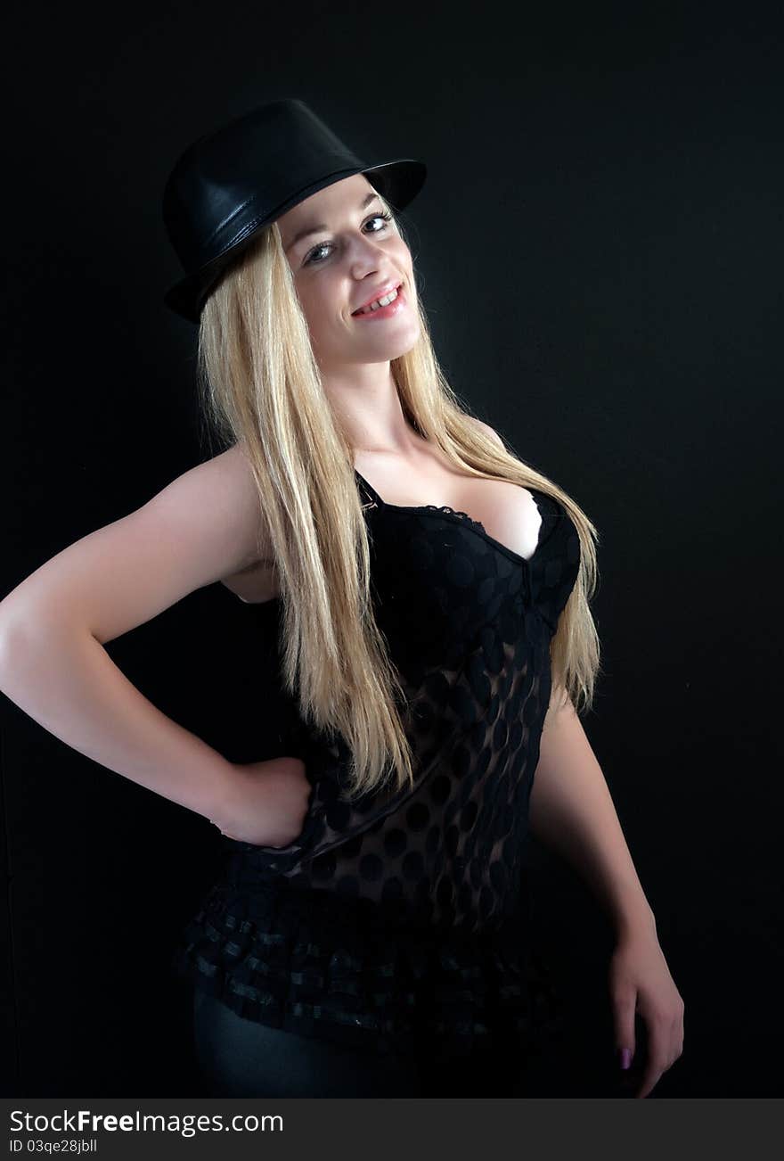 Amazing blond girl in black cloth look at camera over black background