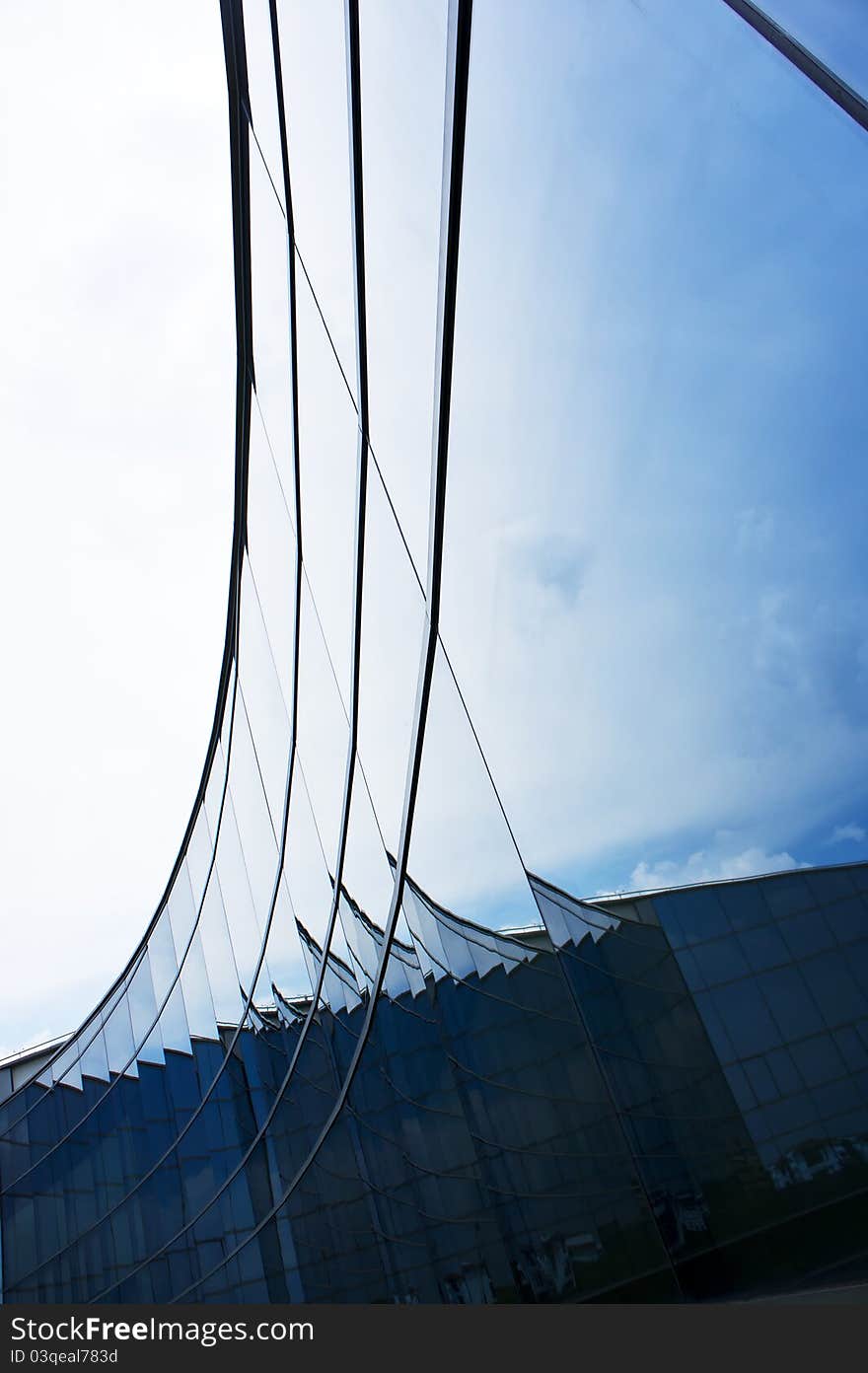 Blue Curve arc glass structure reflecting the clear sky. Blue Curve arc glass structure reflecting the clear sky