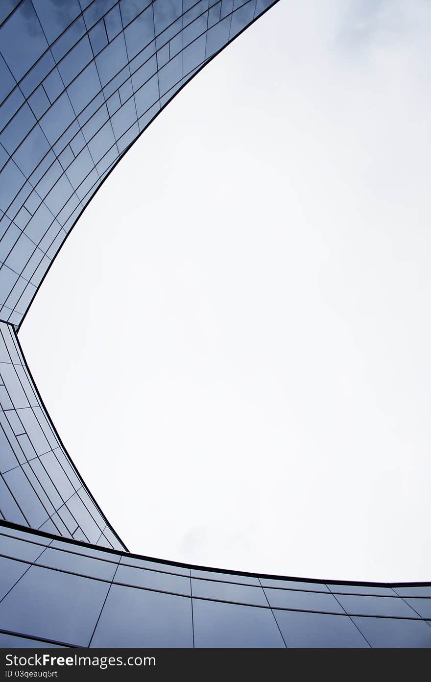 Three Blue Curve arc glass wall building reflecting the clear sky. Three Blue Curve arc glass wall building reflecting the clear sky