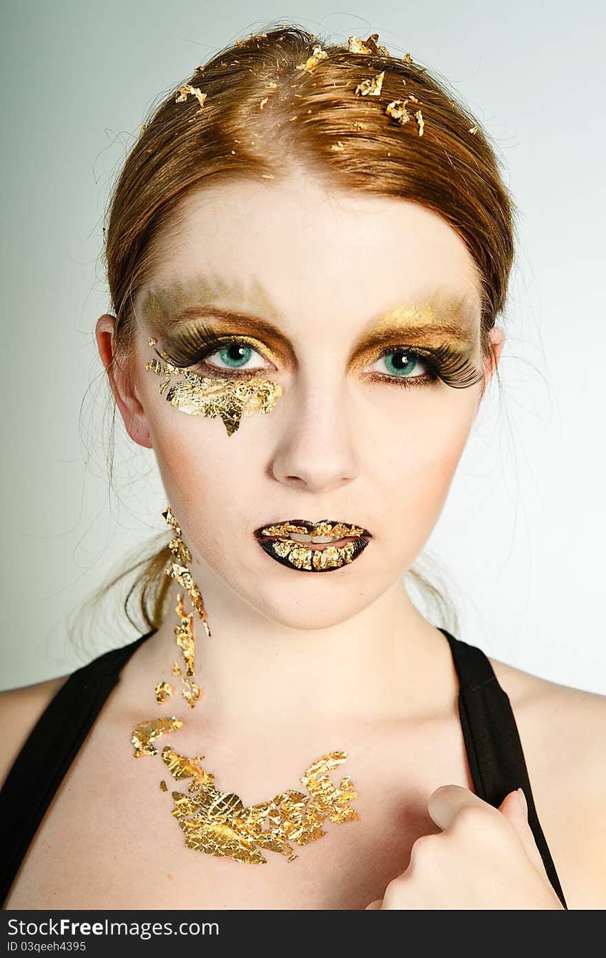 Blonde woman with leaf gold on her face. Blonde woman with leaf gold on her face