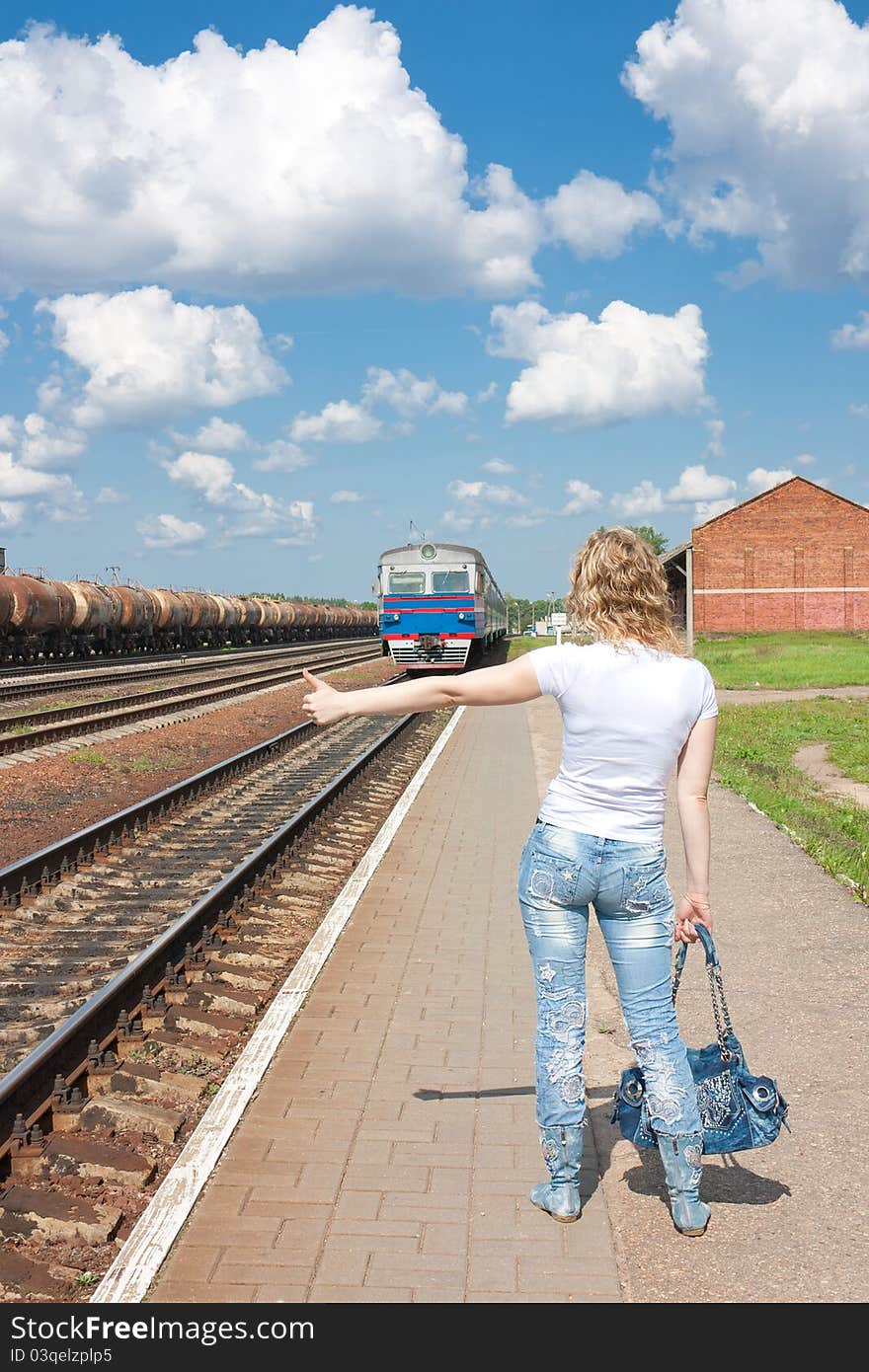 The girl votes before train at station in a clear sunny day. The girl votes before train at station in a clear sunny day