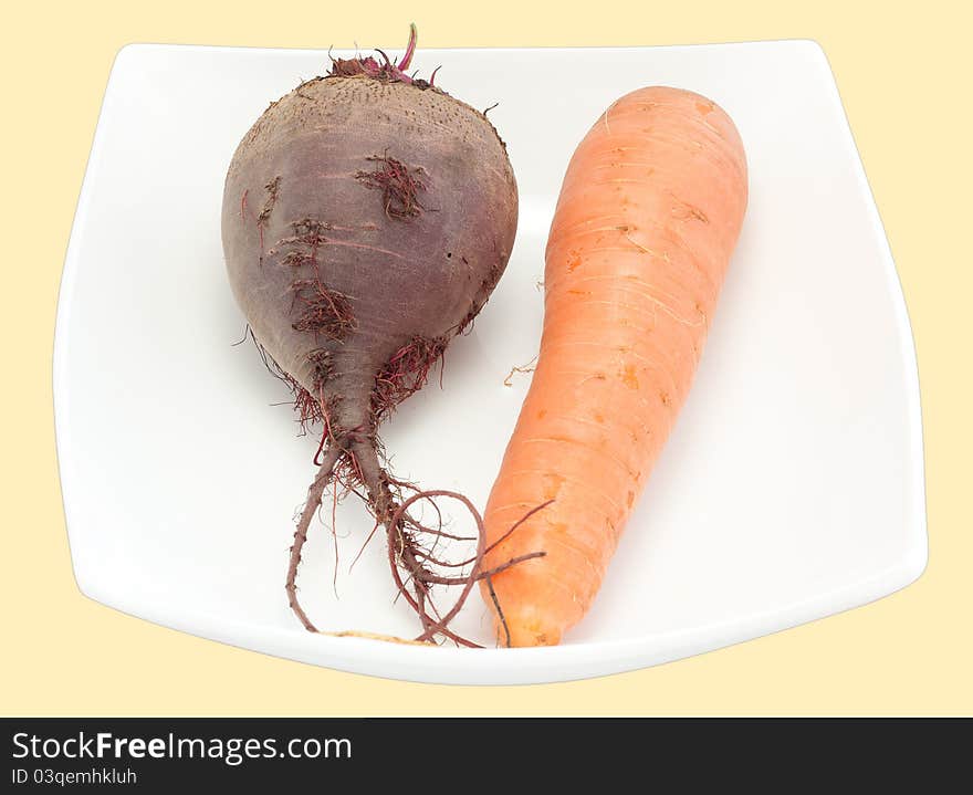 Crude carrots and beet in a plate it is isolated a close up. Crude carrots and beet in a plate it is isolated a close up