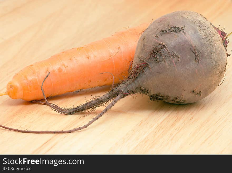 Carrots and beet on a wooden background