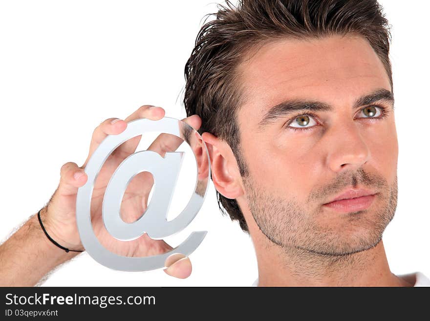 Closeup of man holding an @ sign