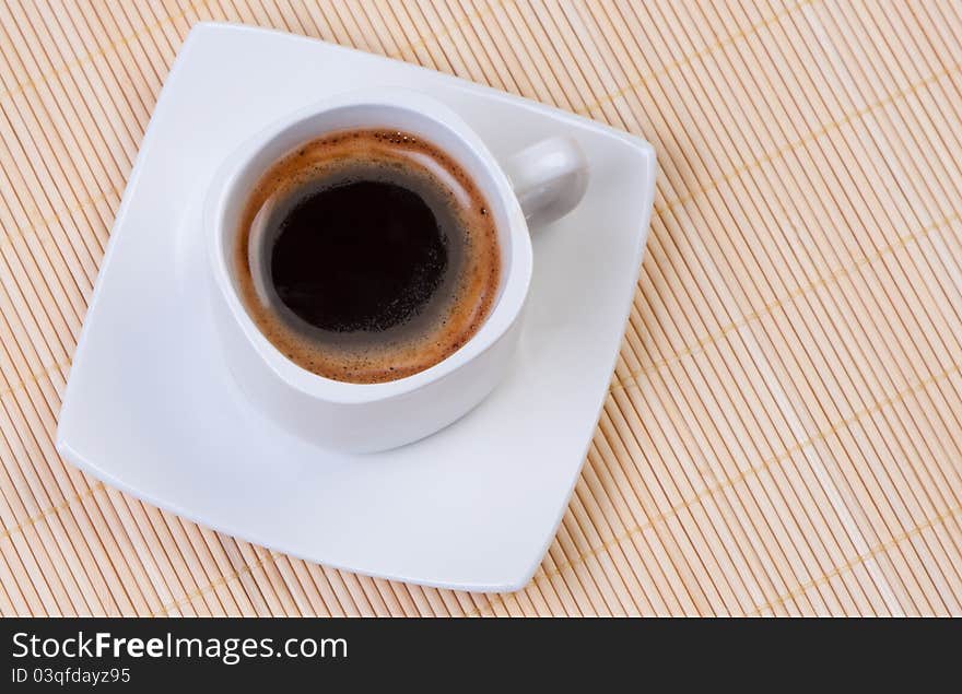 Coffee cup on bamboo mat.