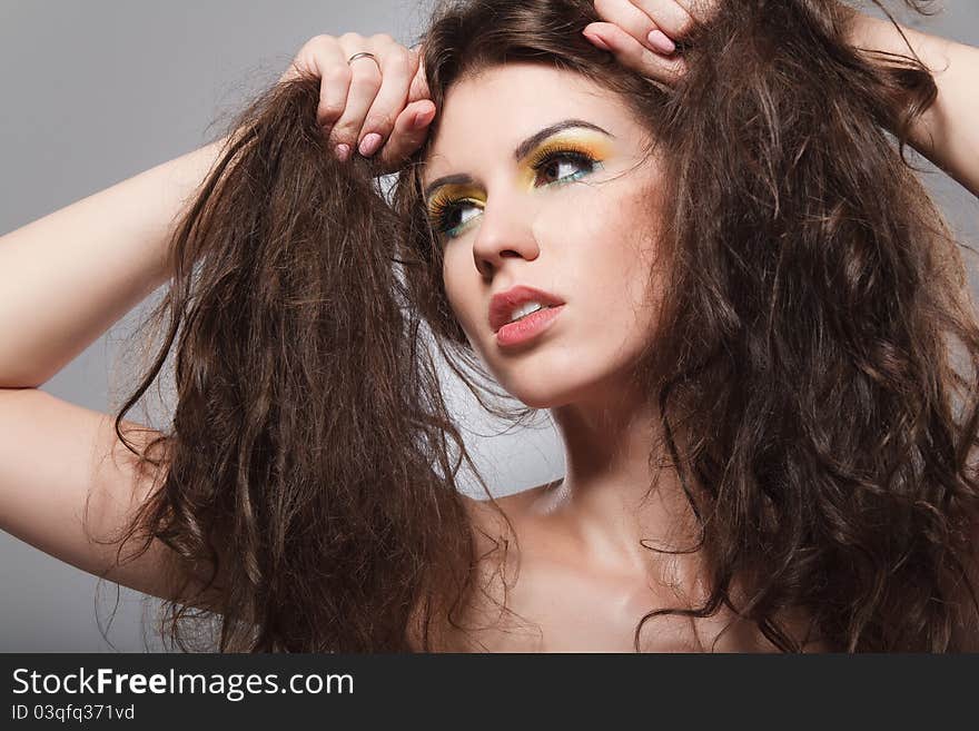 Portrait of a young brunette lady on grey background. Portrait of a young brunette lady on grey background