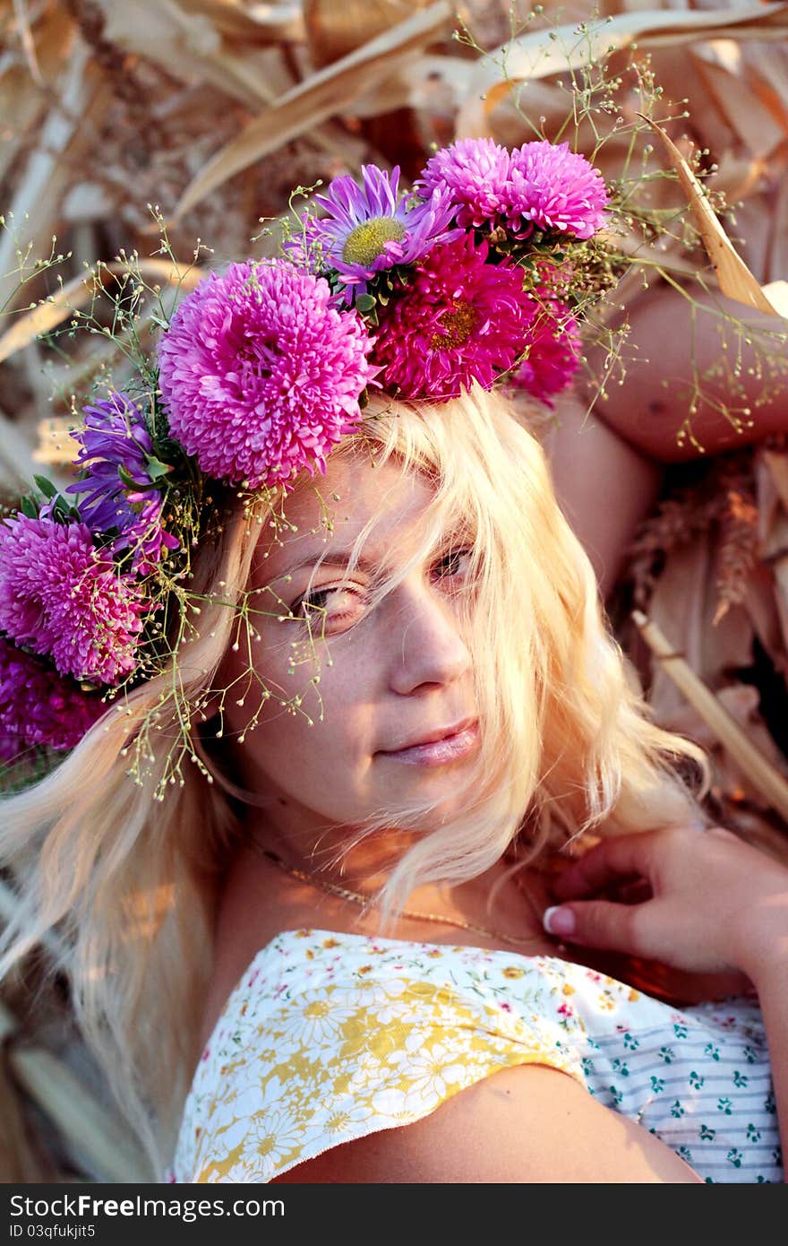 Young woman in corn haystack with wreath