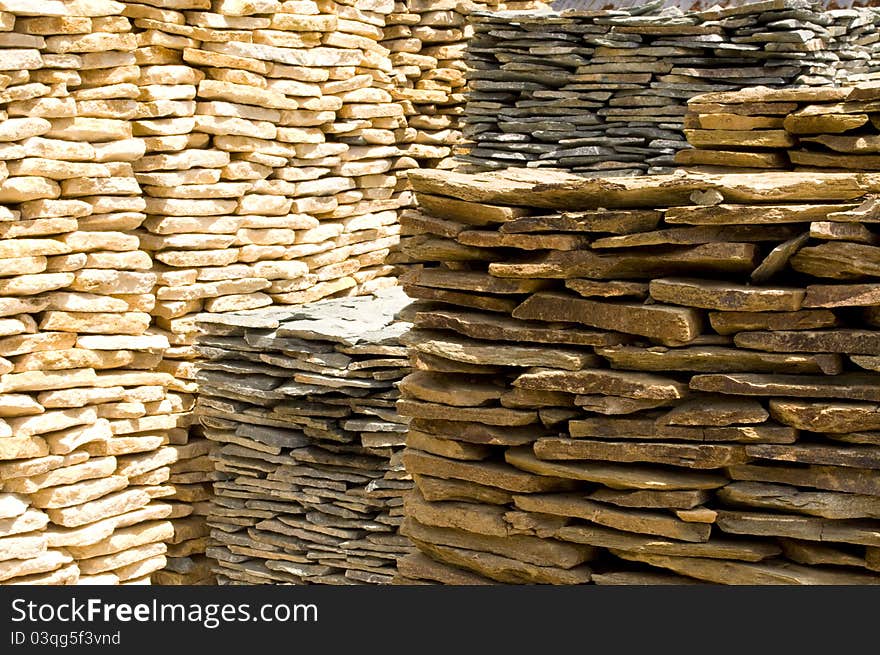 Large stacks of golden and cream colored rock slabs. Large stacks of golden and cream colored rock slabs.