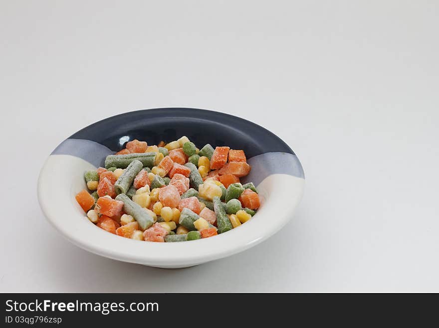 A Bowl of frozen mixed vegetables...in white background