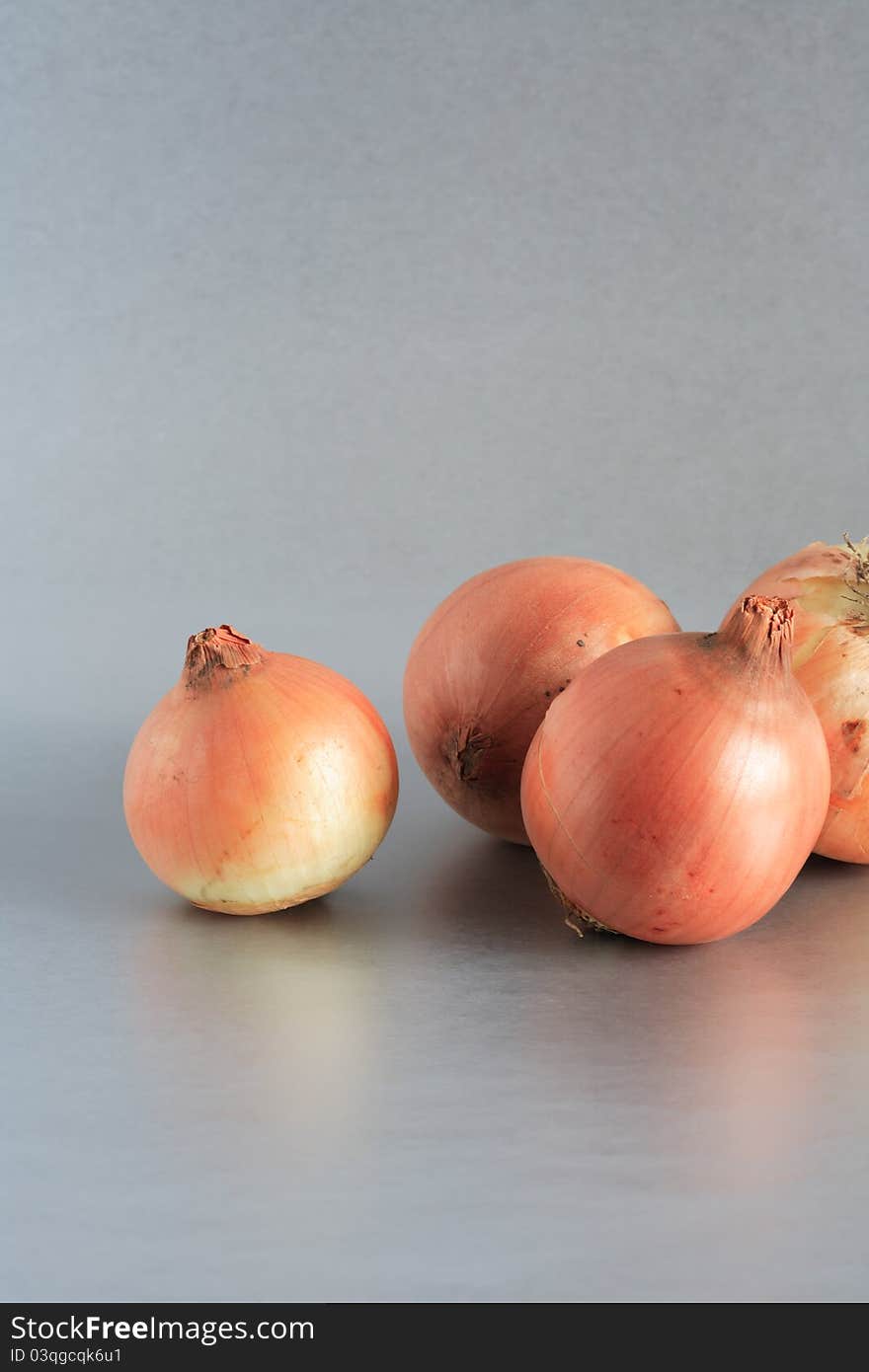 Closeup of few onions on beautiful gray background. Closeup of few onions on beautiful gray background