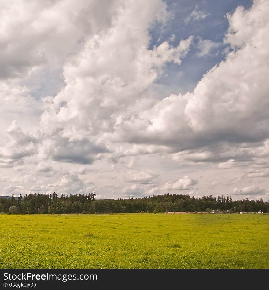 Retro colors shot - Green meadow and sky with many clouds