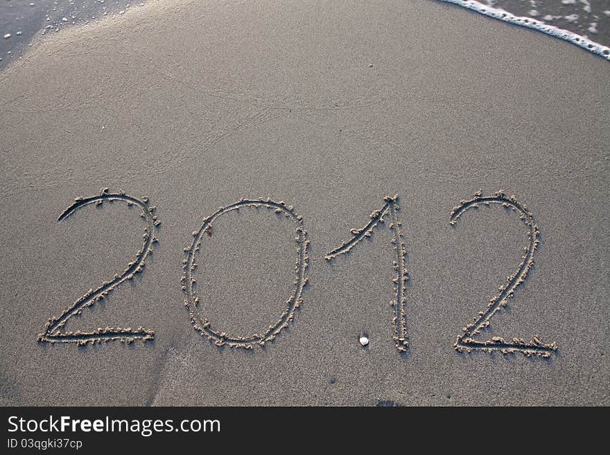 New year 2012 on the beach written on the sand