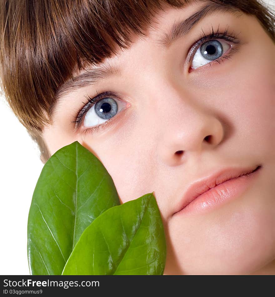 Beautiful young girl with green leaves on white background. Beautiful young girl with green leaves on white background