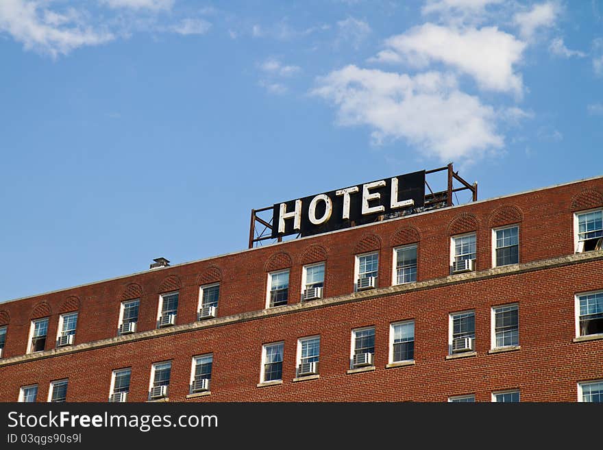 Hotel sign on an old brick building against a blue sky