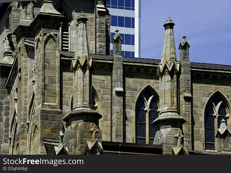 Two buildings one old of stone and one new with glass. Two buildings one old of stone and one new with glass.