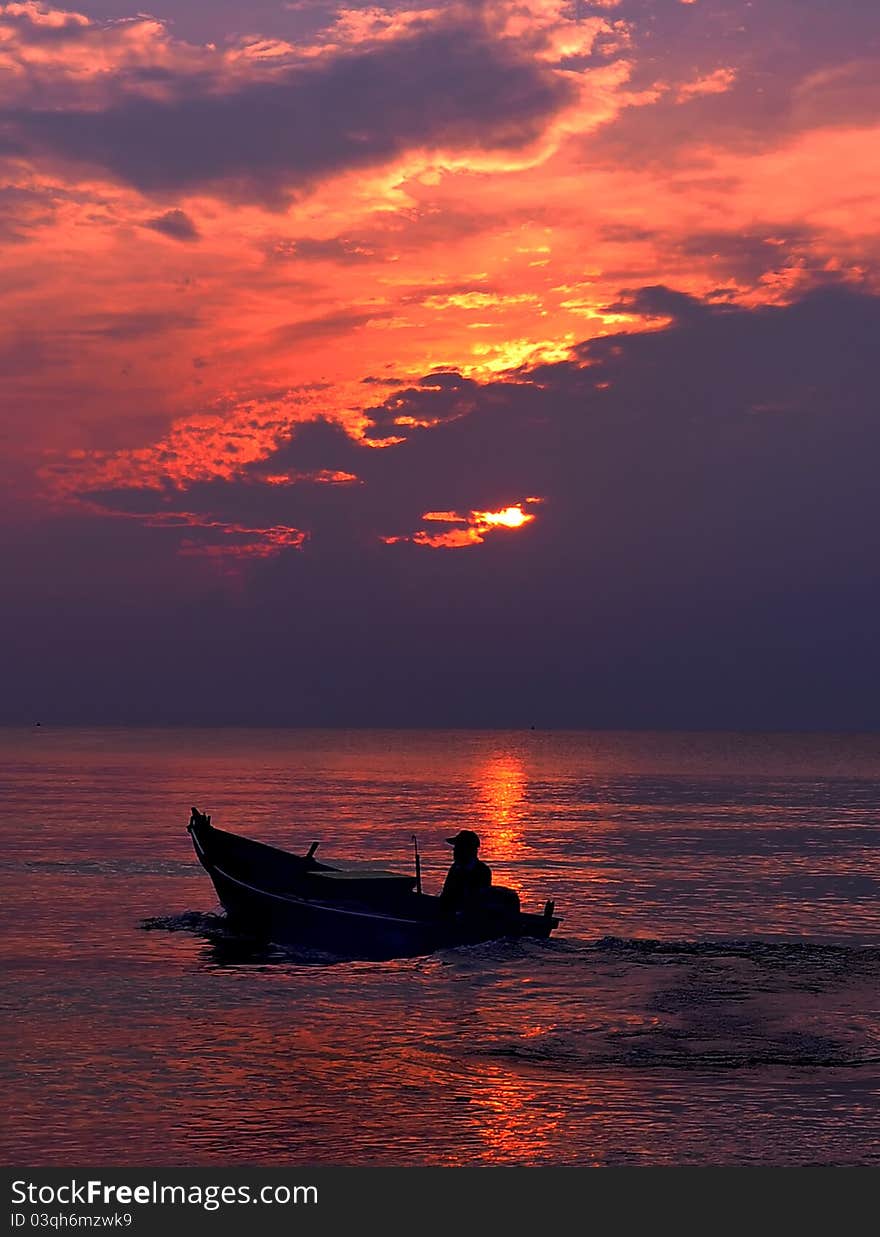 Fishermen in boat at sunrise