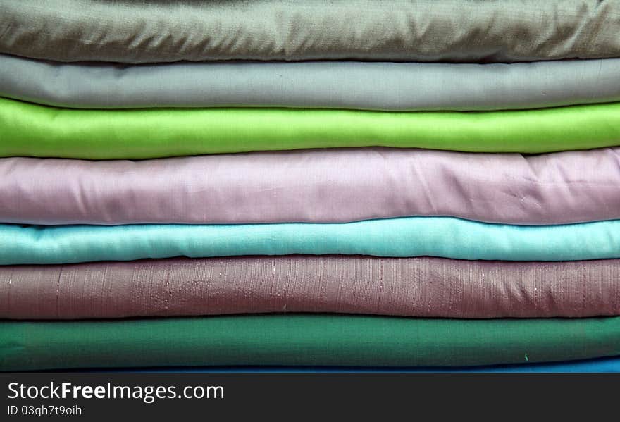 Stack of colorful praewa silk fabric cloth using as background. Stack of colorful praewa silk fabric cloth using as background
