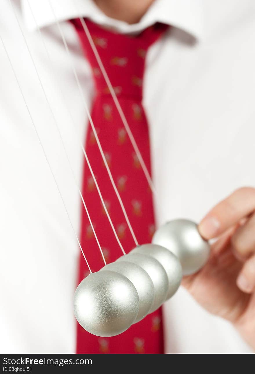 Businessman holding a pendulum ball. Businessman holding a pendulum ball