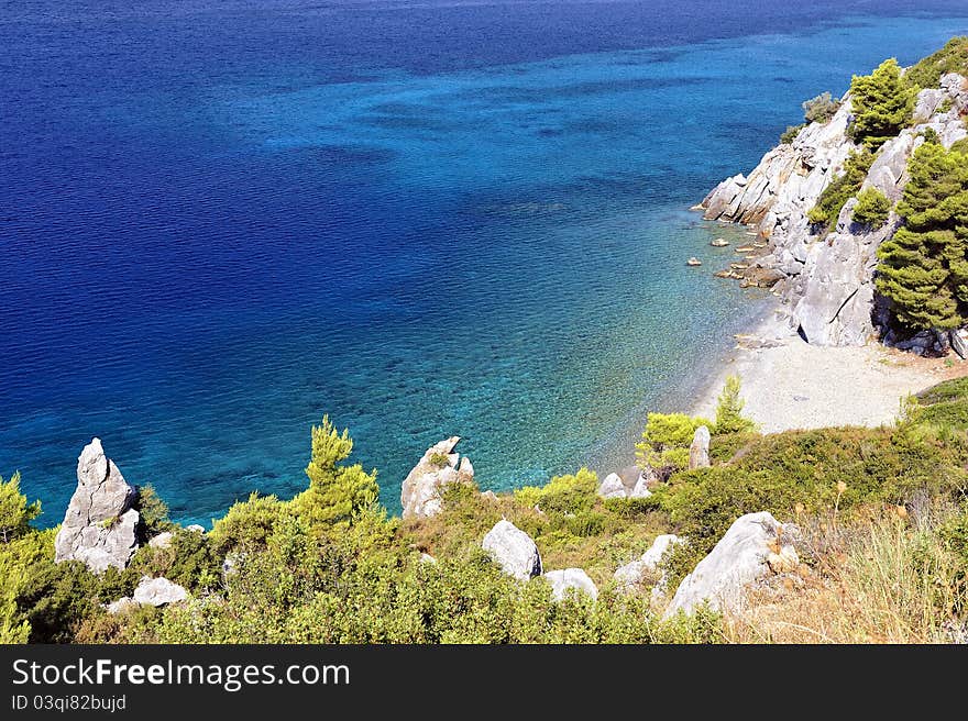 Clear sea water with stones and green tropical coastline. Clear sea water with stones and green tropical coastline