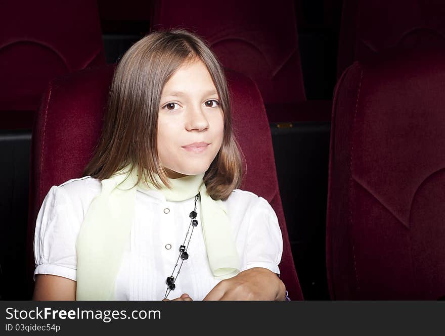 Girl sitting alone in the cinema and watching a movie. Girl sitting alone in the cinema and watching a movie