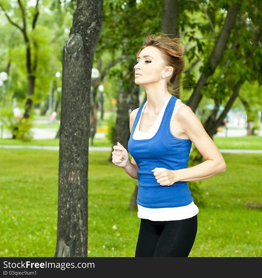 Young Woman Jogging In The Park In Summer