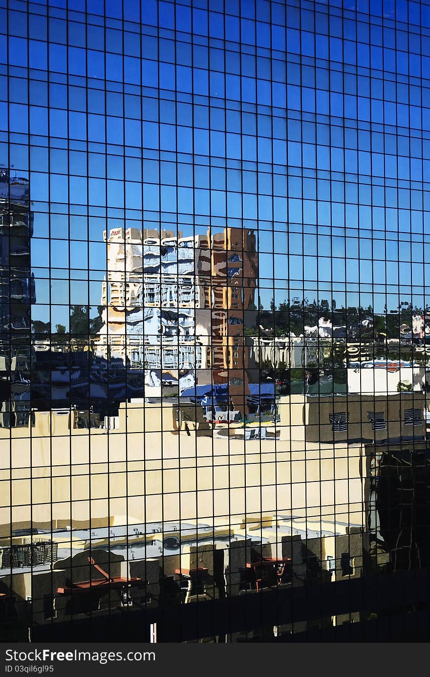 The city reflects off an exterior wall of a glass building. The city reflects off an exterior wall of a glass building