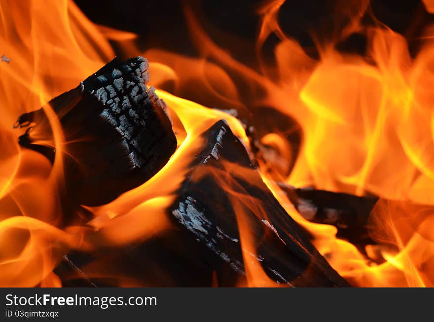 A log burning with a yellow orange flame. A log burning with a yellow orange flame.