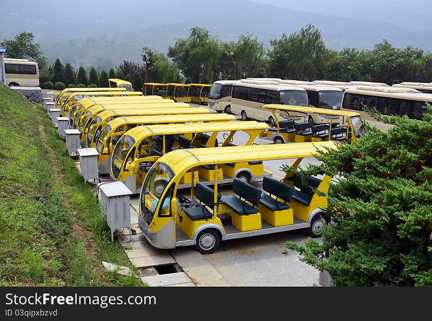 Parking place with electrical yellow buses for touristic transport charging the battery. Parking place with electrical yellow buses for touristic transport charging the battery