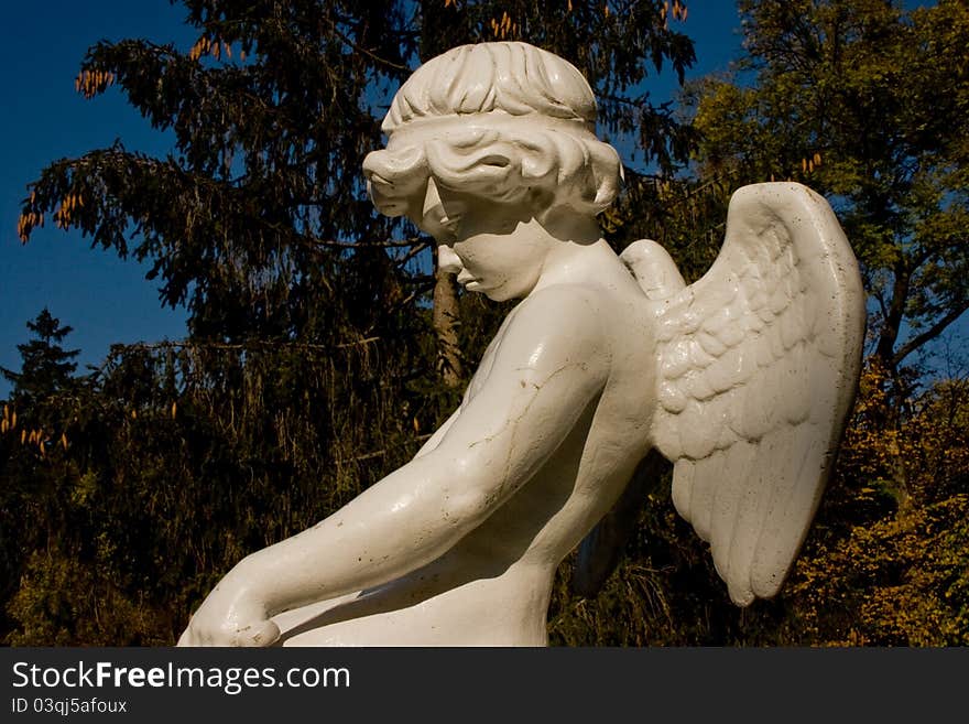 White marble statue of an angel with wings on his back