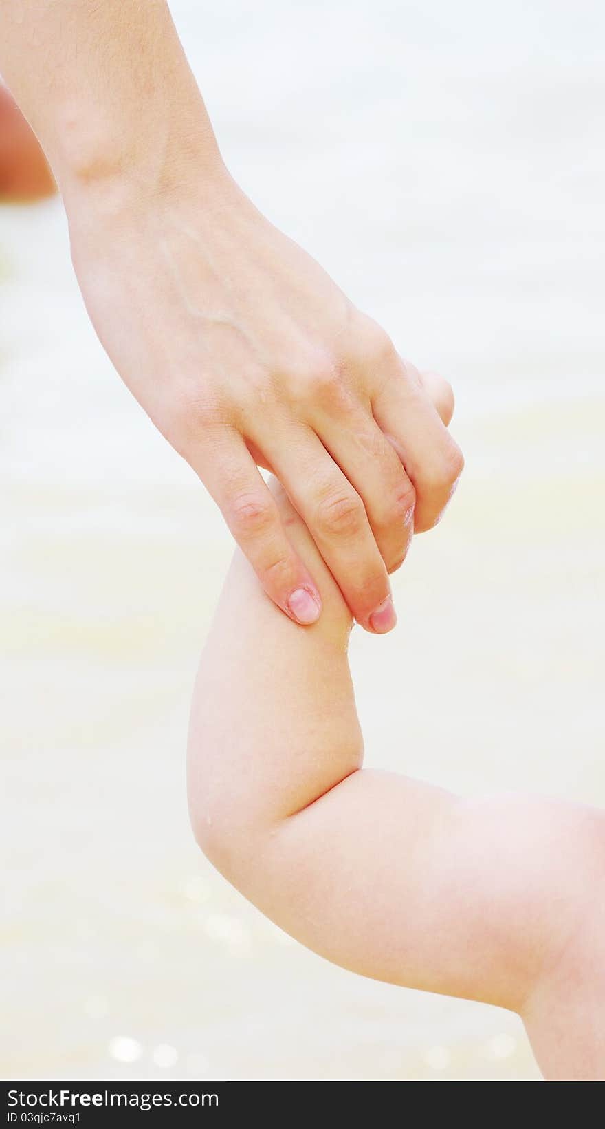 Baby hand holding mother finger on white